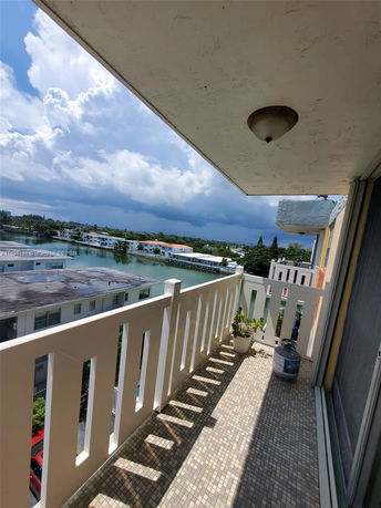 View from a balcony overlooking a body of water and buildings in the distance.