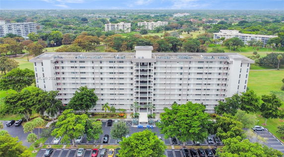 Front view of a multi-story residential building with parking area.