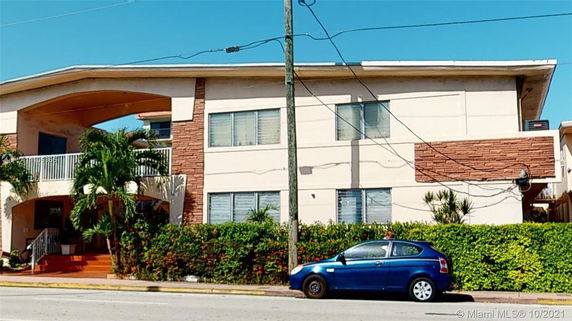 Front view of a two-story building with brick and cream-colored panels.