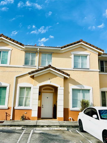 Front view of a two-story townhouse with beige and orange exterior.