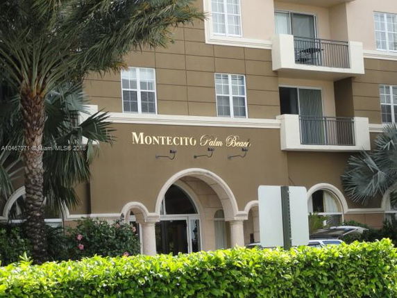 Front view of a multi-story building with balconies and arched entrance.