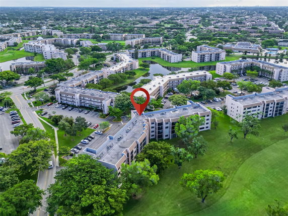 Aerial view of a residential apartment complex with several multi-story buildings and green spaces.