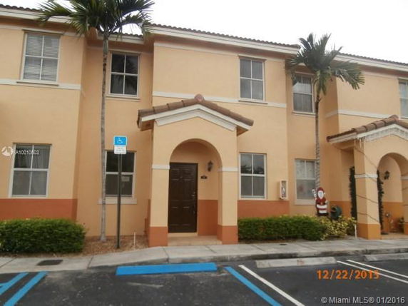 Front view of a two-story house with an arched entrance and beige exterior.