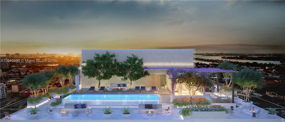 Rooftop area with a pool and lounge seating surrounded by trees.