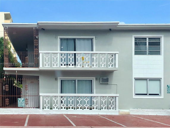 Front view of a two-story building with balconies and decorative railings.