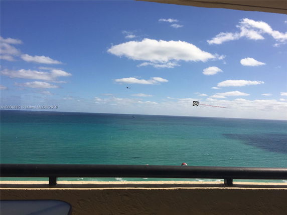 Panoramic view from a balcony overlooking the ocean and sky.