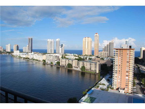 Aerial view of a coastal cityscape with multiple high-rise buildings near the waterfront.