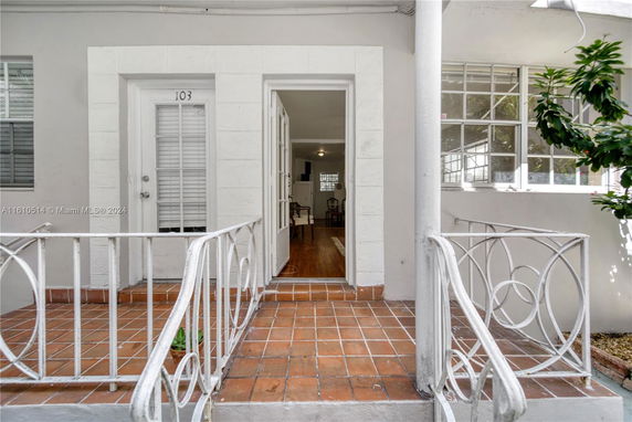 Front entrance view of a house with a tiled porch and decorative railing.