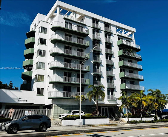 Front view of a multi-story apartment building with balconies.