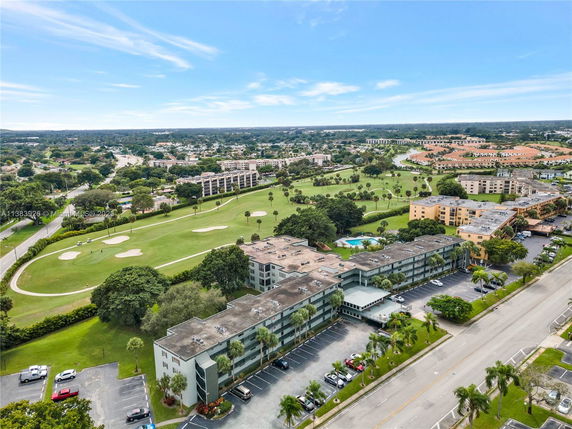 Aerial view of residential buildings and a golf course.