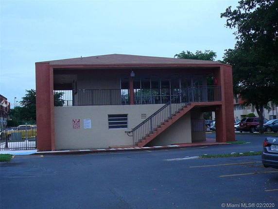 Front view of a two-story rectangular building with exterior stairs.