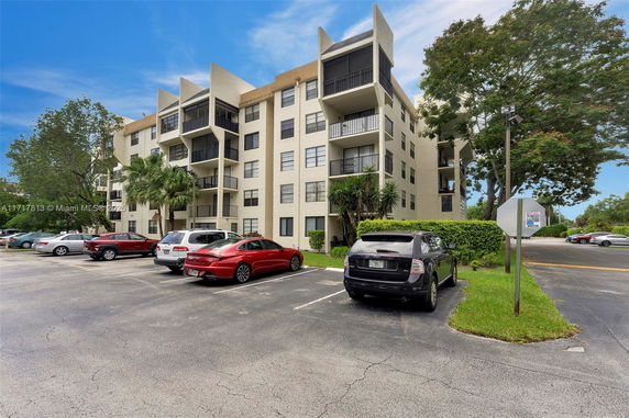 Outdoor parking area in front of a multi-story residential building.