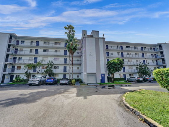 Front view of a multi-story apartment building with balconies.