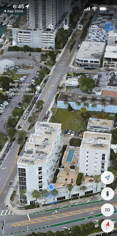 Aerial view of a multi-story building with a swimming pool and surrounding cityscape.
