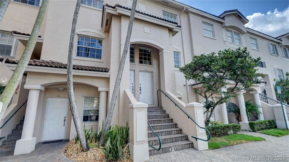 Front view of a multi-story townhouse with stairway entrance.