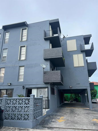 Front view of a multi-story gray building with balconies.
