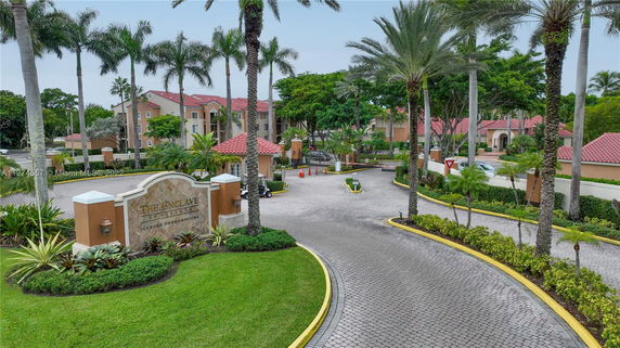Front view of a luxury condominium building with red-tiled roofs and palm trees.