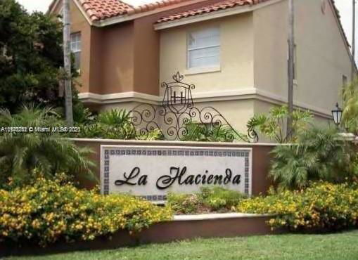 Front view of a two-story house with a decorative emblem and sign reading 'La Hacienda.'