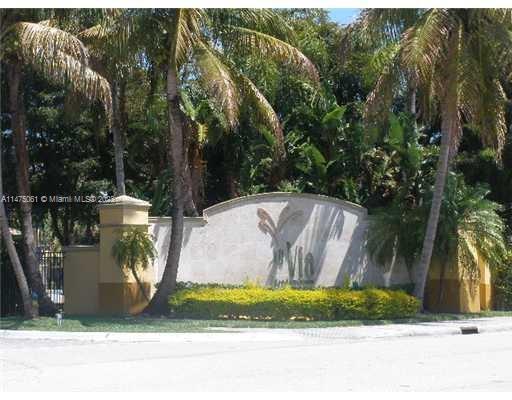 Front view of an entrance wall with palm trees.