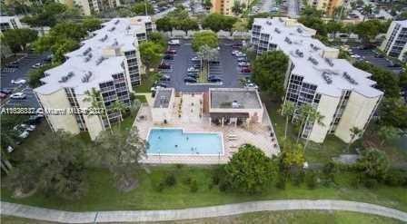 Aerial view of an apartment complex with a central swimming pool and parking area.