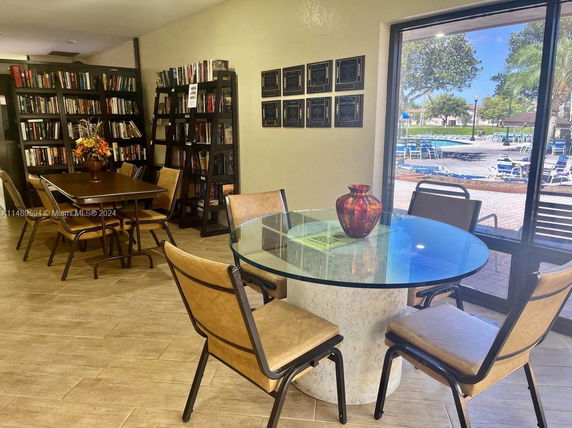 Interior view of a recreational room with bookshelves and tables in a building.