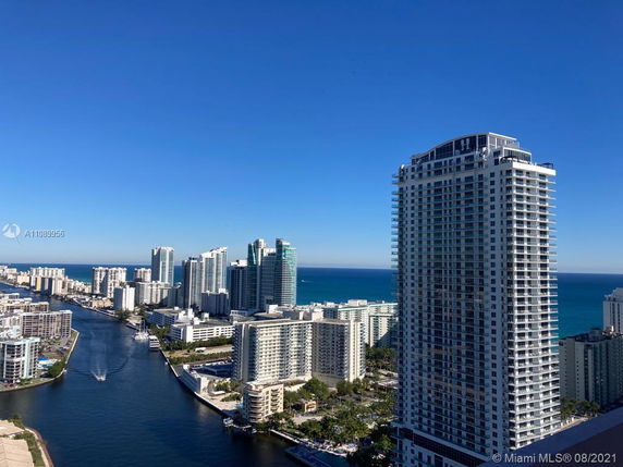 Panoramic view of a coastal cityscape with high-rise buildings and a waterway.