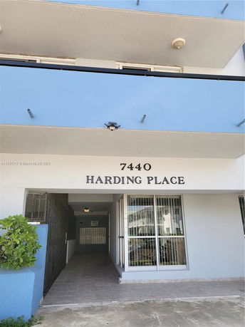 Front view of a building entrance named 7440 Harding Place with a passageway leading inside.