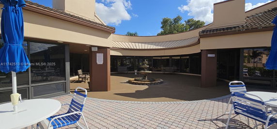 Outdoor area of a building with seating and a fountain.
