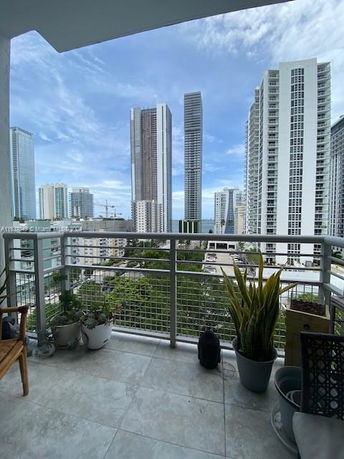 View from a balcony overlooking tall buildings and cityscape.