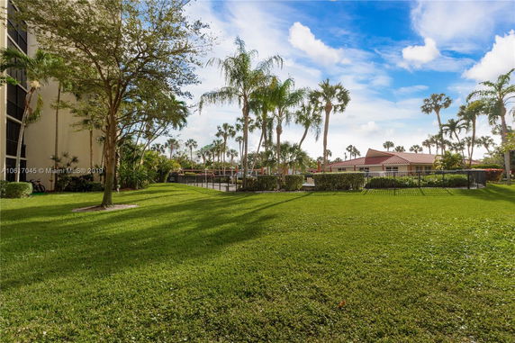 View of surrounding areas with palm trees and a building with a red roof.