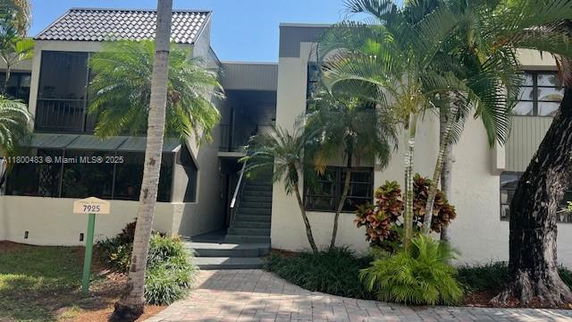 Front view of a residential building with palm trees.