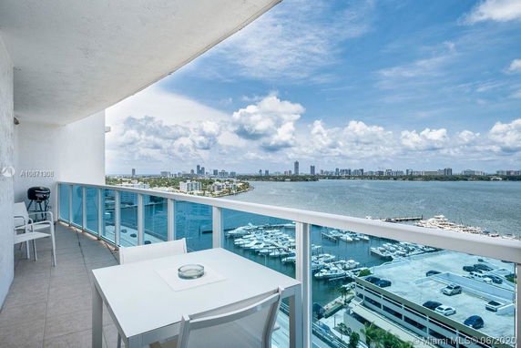 Panoramic view from a balcony overlooking a waterfront and city skyline.