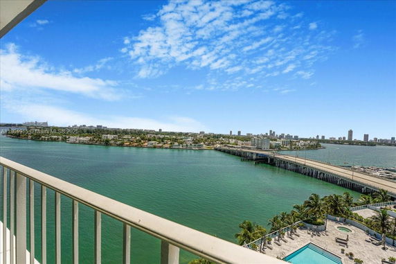 Panoramic view of a city skyline and waterfront from a balcony.