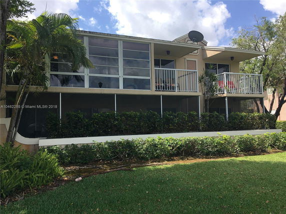 Front view of a two-story building with balconies and large windows.