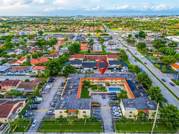 Aerial view of a residential area with multiple buildings and a marked location.