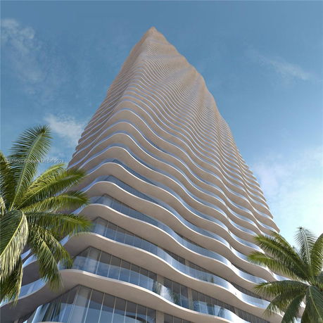 Upward view of a modern high-rise building with wavy architectural design.