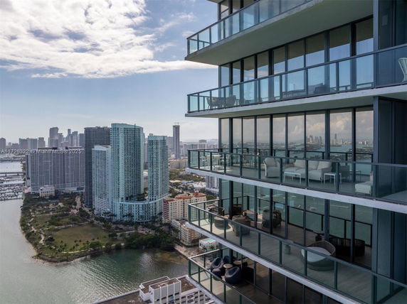High-rise building with multiple glass balconies overlooking the city and water.