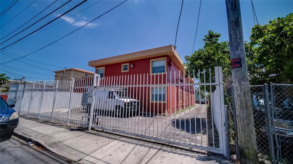 Front view of a two-story building with a gated driveway.