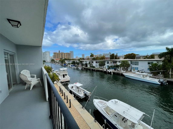 View from a balcony overlooking a canal with boats and waterfront buildings.