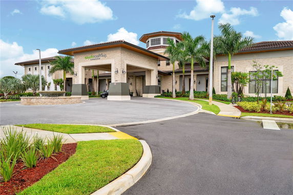 Front view of a large building with a covered entryway and landscaped surroundings.