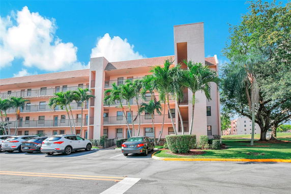 Front view of a multi-story building with a parking area in front.