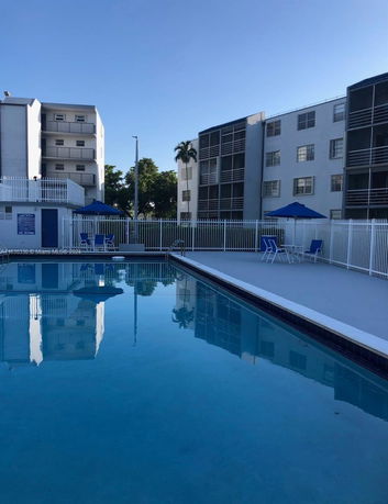 View of outdoor swimming pool adjacent to residential buildings.