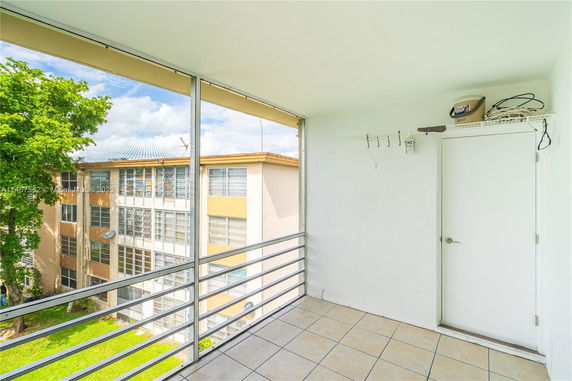 View from an enclosed balcony overlooking a building with multiple windows.