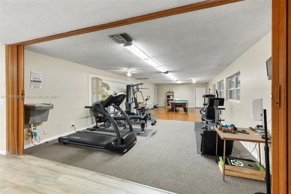 Indoor recreation area with exercise equipment and a billiards table.