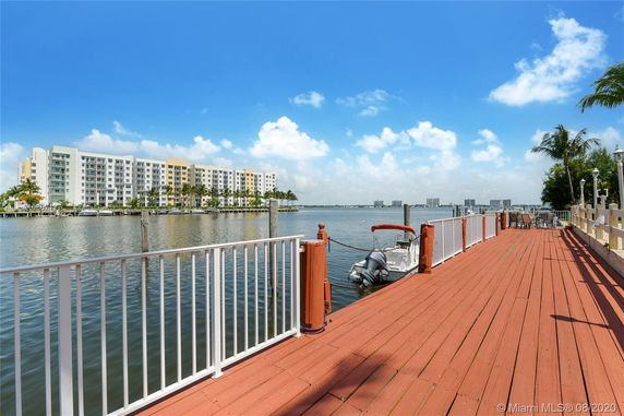 View of a waterfront area with a small boat docked, overlooking a large building and waterway.