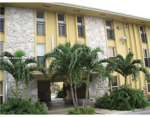 Front view of a multi-story building with stone facade and balconies.