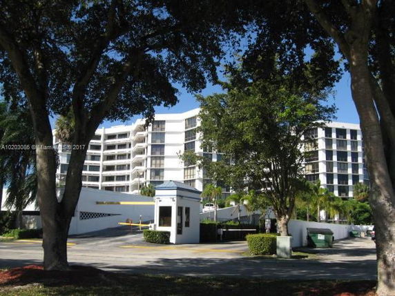 Front view of a multi-story building with balconies and a gated entrance.