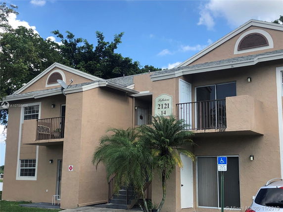 Front view of a two-story building with balconies and a satellite dish.