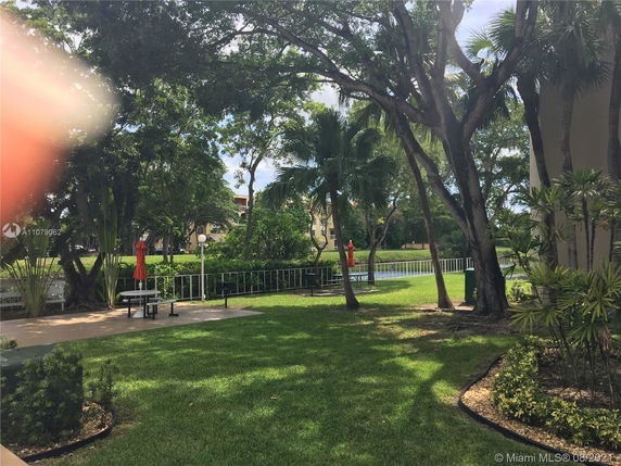 View of a landscaped outdoor area with trees and a picnic table.