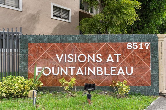 Signage for 'Visions at Fountainbleau' on a stone wall in front of a building.